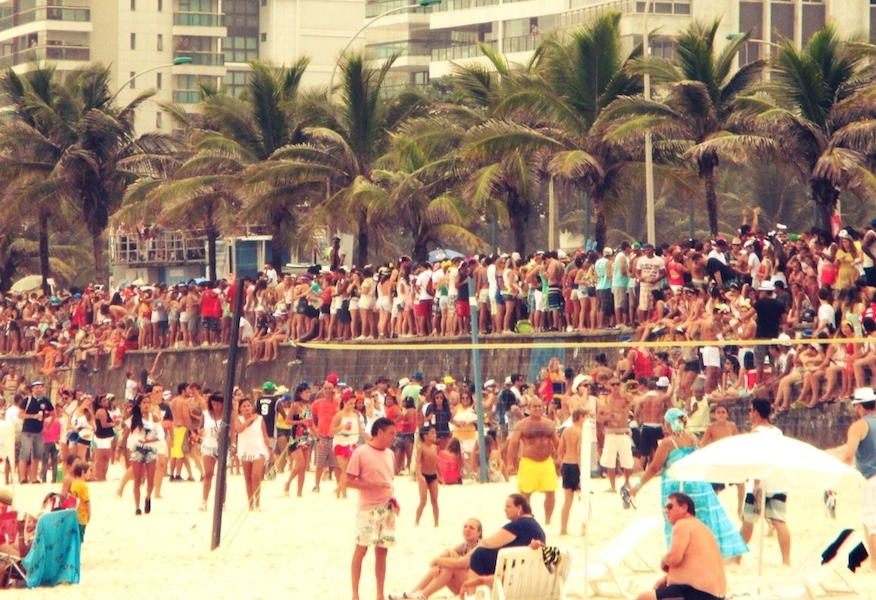 Menschenmengen unter Palmen am Strand beim Karneval in Rio