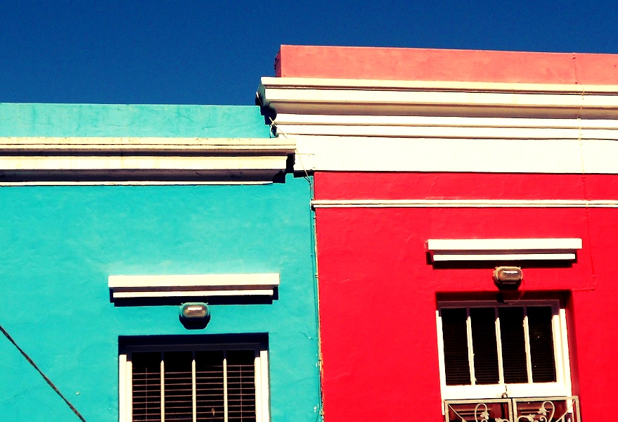 Ein türkisfarbenes und ein knallrotes Haus nebeneinander in Bo Kaap in Kapstadt, Südafrika
