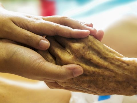 Danke an Pflegekräfte: eine junge Hand hält liebevoll eine alte Hand