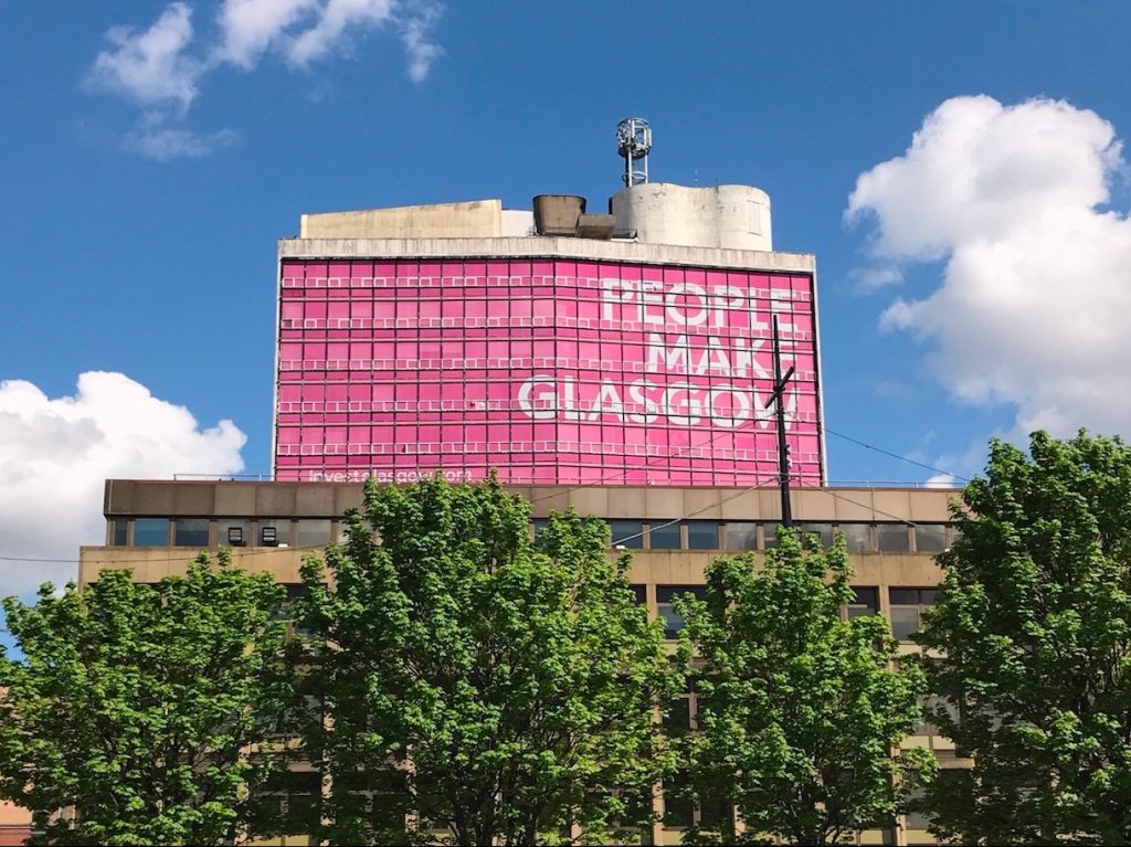 Schottland: Foto eines Hochhauses in Glasgow mit der Aufschrift "The People Make Glasgow"