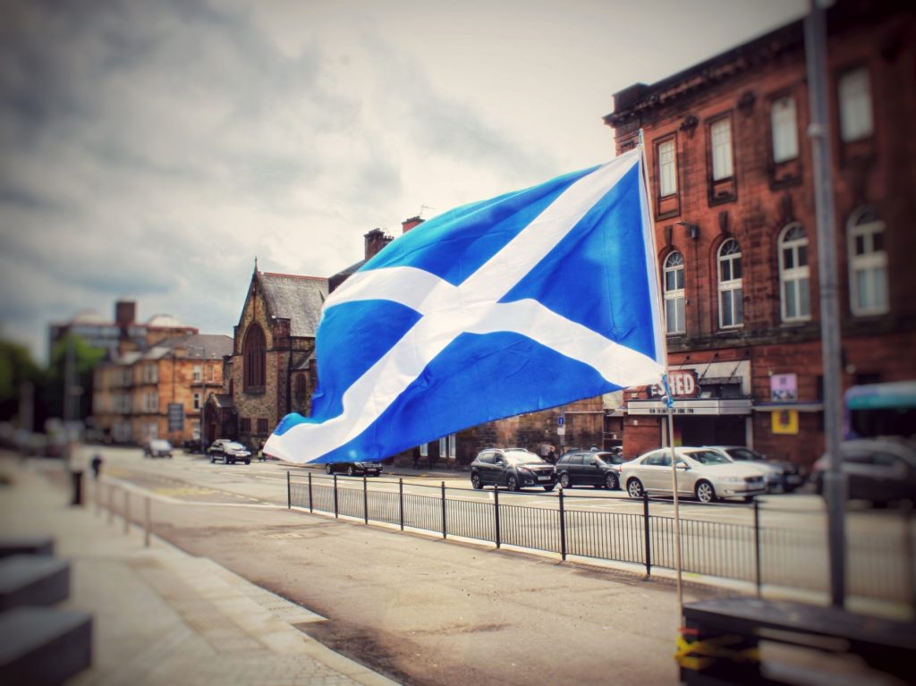 Brexit in Schottland: blauweiße schottische Flagge mit Andreaskreuz vor einem Sandsteingebäude in Glasgow