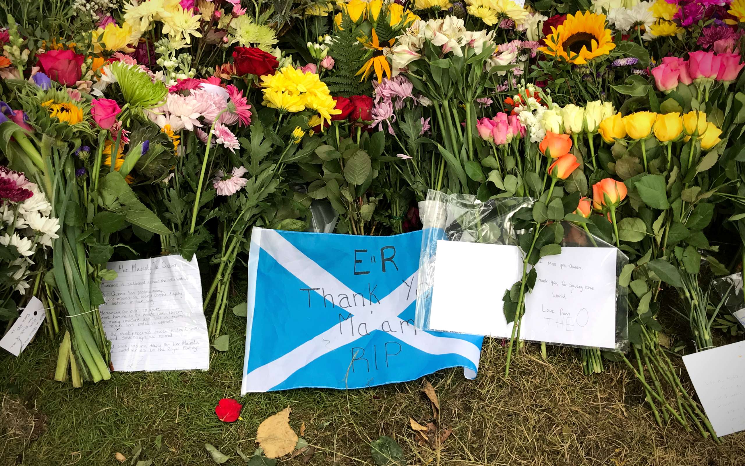 Tod der Queen: Schottische Flagge mit der Aufschrift Thank You, Ma'am RIP inmitten von Blumen im Holyrood Palast in Edinburgh